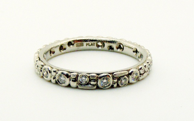 R117P
“Mini 62” Platinum and diamond ring with 17-18 diamonds totaling approximately 0.23 ct. 2.5mm wide. Immediately available in size 6 ½. 
$3,340.00
