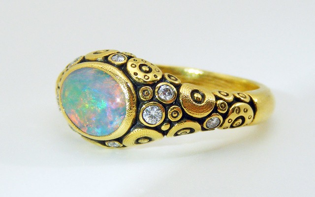 R-79M 
Ring is 18K yellow gold with a 1.17 ct Black Opal center gemstone and 9 diamonds of 0.18 ct total (F-G/VVS).  
Available for immediate delivery in finger size 6 ½. 
$5,160
