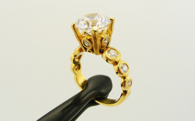 R-193MD 
“Candy” Ring Mounting, 18K yellow gold, Cubic Zirconia center stone (center fits a 8.5-9.5mm  round stone), 10 accent diamonds totaling 0.42ct. 
Available for immediate delivery in size 5 ¾. 
$4,180 
