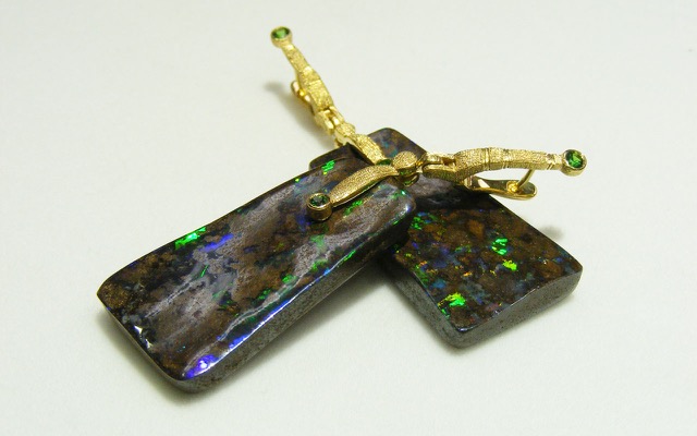 E167
“Sticks & Stones” opal earrings in 18K yellow gold with boulder opal drops and 2 Tsavorite garnets. Veins of brilliant multi-colored opal course through fields of rich brown ironstone matrix in this dramatic pair of matrix boulder opals from Queensland, Australia. The opals total 65.61 cts.
Immediate delivery 
SOLD
