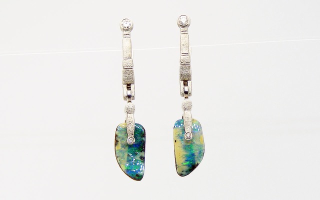E142PMD
“Sticks & Stones” earrings in platinum with boulder opal drops and 4 diamonds totaling 0.13 cts. The wing-shaped Boulder Opal Splits are from Queensland, Australia and total 5.13 cts. ”Splits” are facing pieces from a single seam of opal and while not identical, they often make wonderful earring pairs. Splits commonly have irregular surfaces and will fit together like puzzle pieces!
Immediate delivery
$4300
