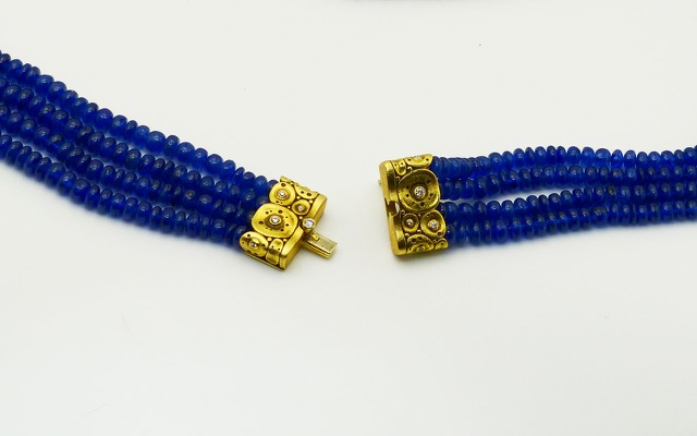 M-72C
Four strand necklace of royal blue sapphire rondelle beads, with Alex’s 18K yellow gold and diamond “Lilies” clasp. The sapphires total 585 carats, 11 diamonds in the clasp total 0.21 ct. 
Immediate delivery
$12,110.00

